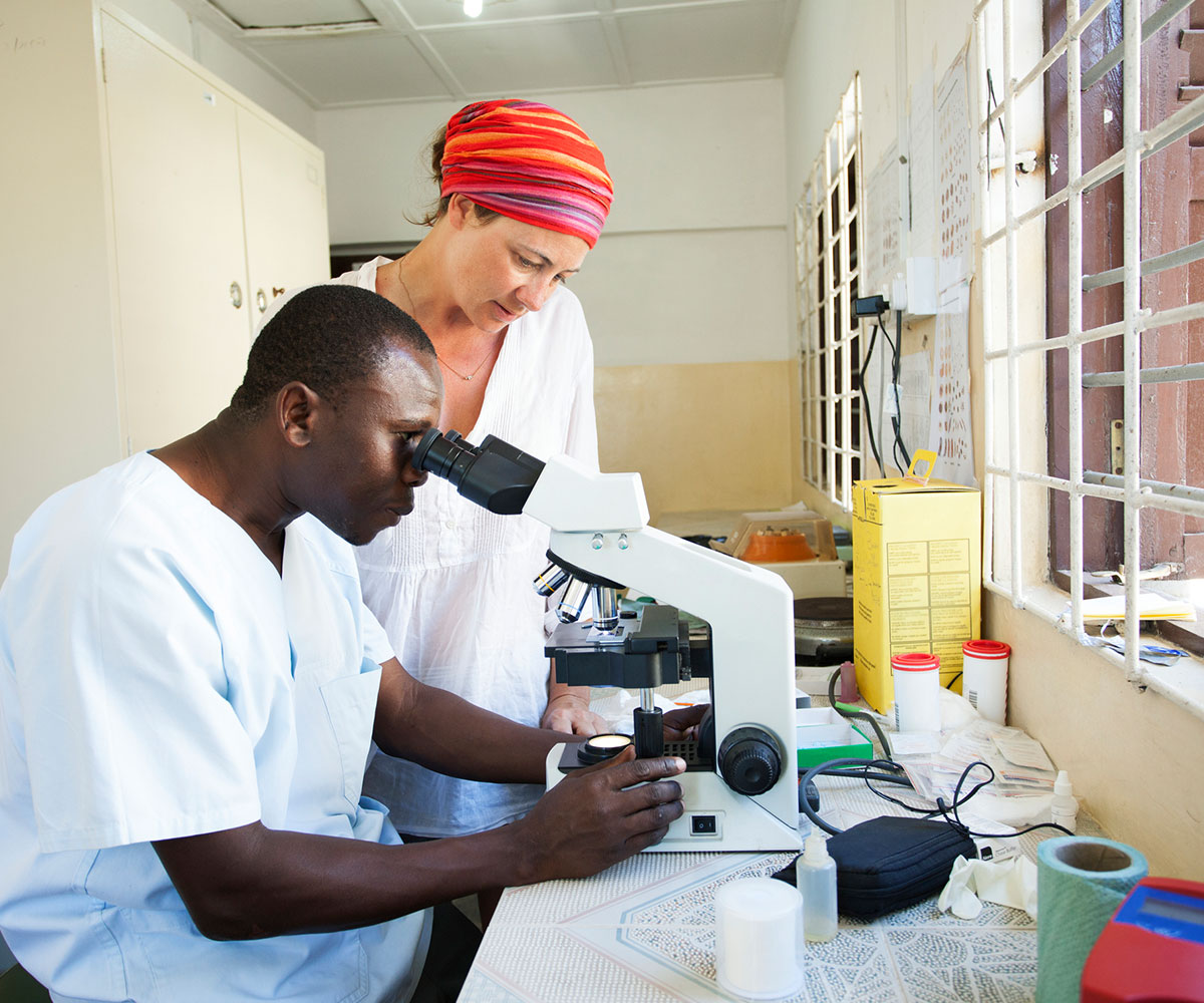 Man and women analyzing using microscope