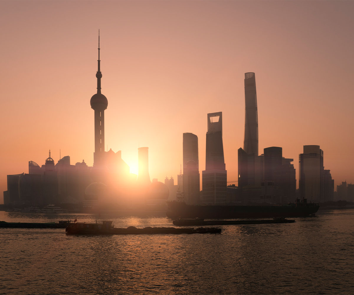 Shanghai morning city skyline silhouette over river with sunrise and Oriental Pearl Tower