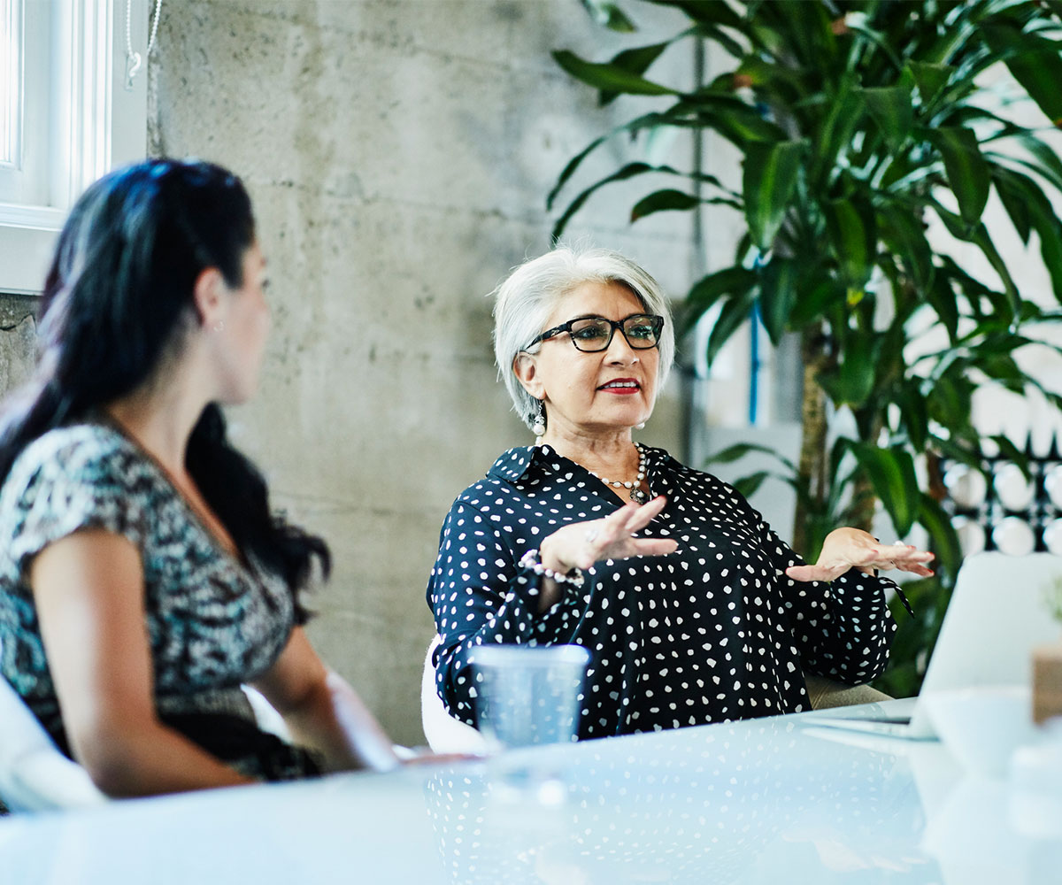 Mature female business owner leading team discussion during project meeting in conference room