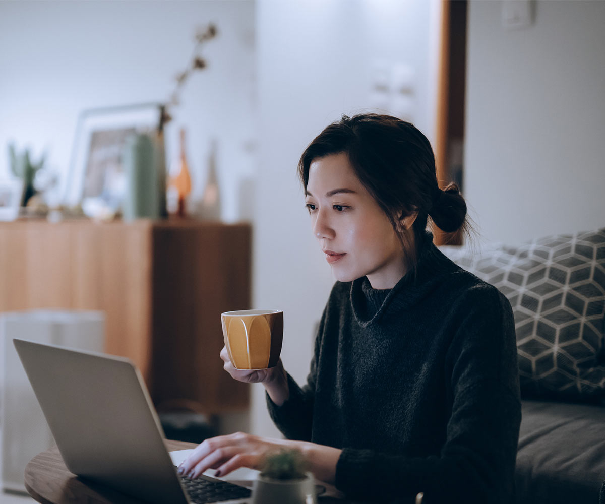 Busy concentrated young Asian woman working from home